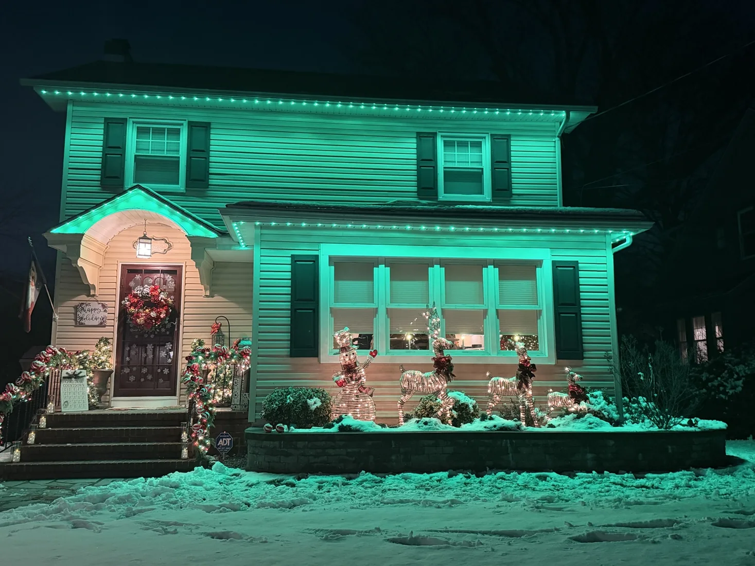 House glowing with teal permanent architectural lighting