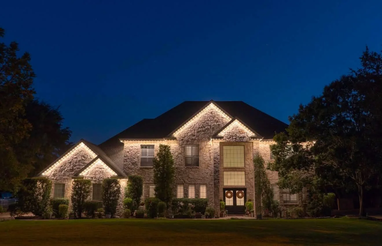 Stone home illuminated in elegant warm white permanent lighting