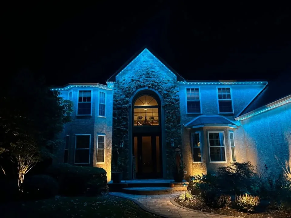 Blue architectural lighting across a stone home