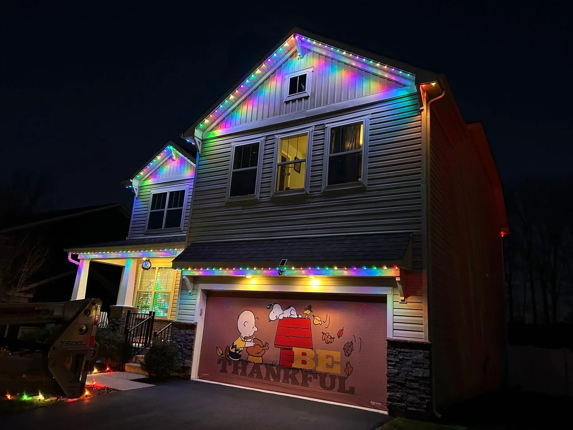Close view of multicolor roofline lighting washing siding on a two story house