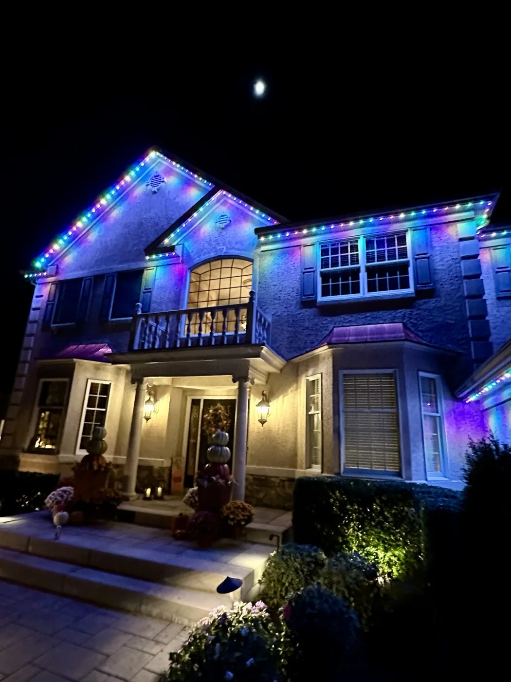 Rainbow lighting washing the front of a large home