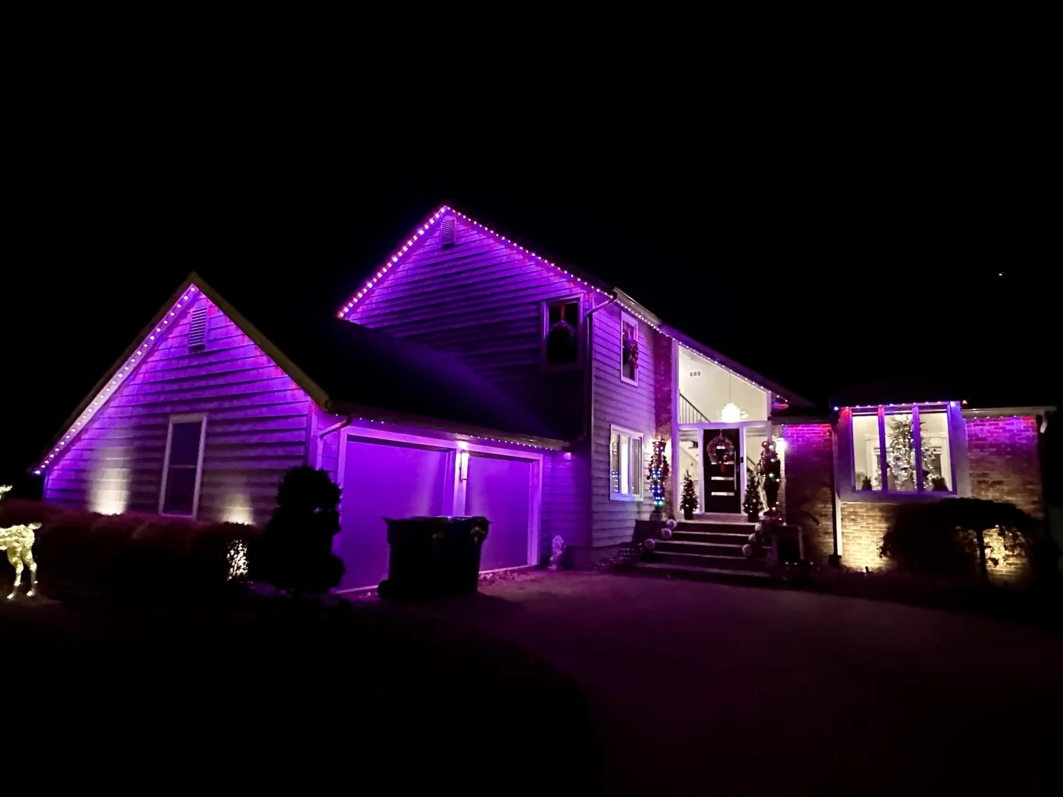 Colorful permanent lighting washing down a home's roofline and exterior